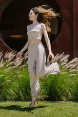 Pantalón de vestir color beige, de corte palazzo y tiro alto, con bolsillos laterales y cintura elástica.