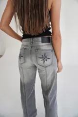 Pantalón de jean recto de tiro medio color gris oscuro con costuras verticales.