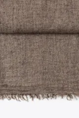 Pañuelo rectangular color marrón oscuro, confeccionado en tejido rústico con lana y terminaciones deshilachadas.