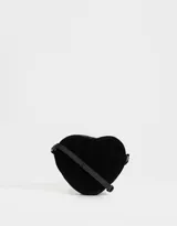 Bandolera negra en forma de corazón, confeccionada en cuerina acolchada con pespuntes verticales. Tiene correa larga regulable y cierre superior.