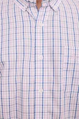 Camisa de manga larga con estampado a cuadros en tonos azul, gris y blanco. Tiene cuello abotonado, bolsillo en el pecho y corte clásico.