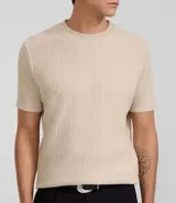 Remera de hombre color beige, corte slim fit, cuello redondo y manga corta. Tejido de punto acanalado texturizado.