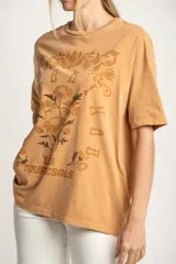 Remera color ocre de corte oversize, con estampado de flores y texto en francés.