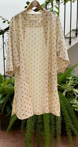 Kimono largo color crudo con estampado de lunares marrones, con mangas 3/4 y bolsillos laterales.