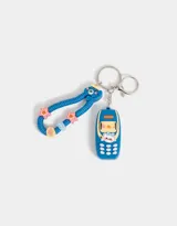 Llavero con dije de celular azul con detalles en amarillo y blanco. Incluye un strap con forma de gusano azul con detalles de estrellas y círculos de colores.