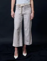 Pantalón capri de lino color beige con estampado floral, marca Zac & Rachel. Tiene pretina con pasadores, cierre y botón. Incluye cinturón de cordones con hebilla metálica. Presenta bolsillos delanteros con botones y bolsillos traseros.
