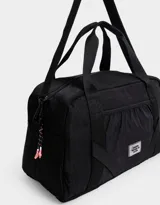 Bolso de tela deportiva color negro, con bolsillo frontal y doble asa corta de mano. Incluye correa regulable y desmontable, cierre superior con tirador de cordón y goma, y tag de goma.