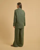 Blazer verde con rayas verticales negras y blancas, cuello de solapa y escote en pico. Mangas largas con hombreras, bolsillos con solapa en la parte delantera y bolsillos ribeteados en el pecho. Forro interior y cierre con botones delanteros.