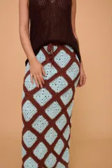 Pollera midi tejida a crochet con diseño de rombos en color marrón y celeste. Tiene elástico en la cintura y llega hasta los tobillos.