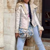 Campera plateada de cuero sintético con cuello y puños de piel sintética color crema.