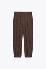 Pantalón bombacho color marrón confeccionado en algodón 100%. Tiro medio con cintura elástica ajustable con cordones y bajo abullonado con elástico.