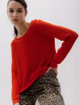 Sweater de punto color rojo ladrillo, de corte holgado y mangas largas.