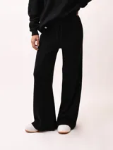 Pantalón palazzo negro de tejido de punto con cintura elastizada y cordón ajustable.