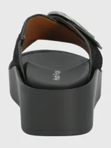 Sandalia negra con plataforma, tiras cruzadas con textura y hebilla circular plateada.