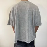 Remera gris con efecto nevado, corte cuadrado y cuello redondo.