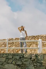 Pantalón de tiro medio con cintura elástica ajustable con cordones, bolsillos delanteros y traseros de parche. Pierna ancha con estampado de rayas verticales azules y blancas.
