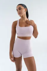Top deportivo color lila, de tejido acanalado, con espalda deportiva y breteles anchos.