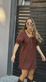 Vestido corto marrón con escote cuadrado, mangas cortas abullonadas con elástico y corte recto.