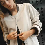 Chaqueta larga color beige de cuero ovino italiano con forro interno y cierre con botones a presión.