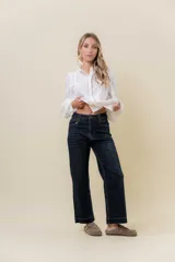 Jean de corte recto y tiro medio en color azul oscuro. Presenta un diseño clásico de cinco bolsillos, cierre frontal con botón y cremallera, y pasacintos.