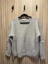 Sweater de punto color crema, con escote en V y apliques de lentejuelas bordadas.