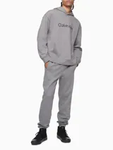 Pantalón de jogging gris de algodón, con cintura elástica, bolsillos laterales y traseros, y logo de Calvin Klein bordado en la pierna izquierda.