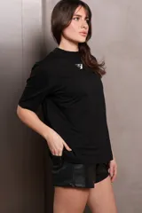 Remera negra de manga corta, cuello alto y logo plateado en el pecho.