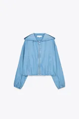 Chaqueta celeste de denim con capucha, cierre frontal con cremallera, bolsillos delanteros y mangas largas con puños elásticos.