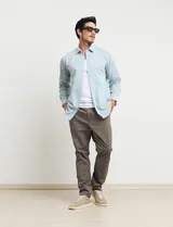 Camisa celeste de manga larga con cuello button-down, confeccionada en tejido rústico de algodón y lino.