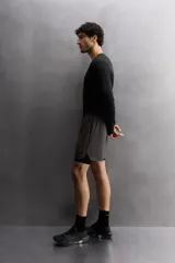 Shorts deportivos color beige con cintura elástica negra, bolsillos laterales y logo estampado en la pierna.