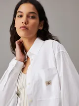 Camisa holgada de popelín de algodón, color blanco, con cuello en punta y bolsillos en el pecho.