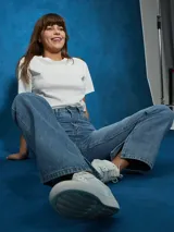 Jean de tiro alto, color negro, con corte recto y detalle de abertura con cierre en el bajo de la pierna.