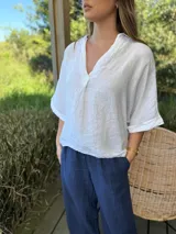 Blusa azul marino de lino, con cuello camisero que forma un escote en V, mangas cortas dobladas y calce holgado.
