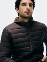 Campera puffer color beige con cierre frontal y bolsillos laterales.