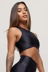 Top deportivo negro con cuello alto y espalda deportiva.