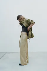 Pantalón cargo color beige de tiro alto con trabillas, bolsillos laterales y de vivo en espalda y pierna. Incluye cinturón lazada en el mismo tejido.