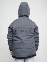 Campera gris con capucha y cierre frontal, con costuras horizontales y logo del Club Atlético Peñarol en el pecho.