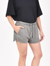 Short negro de tela suave con cintura elástica ajustable con cordón, bolsillos laterales y corte redondeado en los laterales.