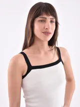Musculosa blanca de tejido acanalado, con tirantes anchos ribeteados en negro y escote cuadrado.
