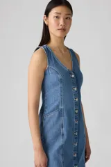 Vestido corto de denim azul con botones frontales, escote en V y sin mangas.