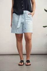 Short de vestir color beige claro, tiro alto, con pliegues frontales y lazo para ajustar la cintura.