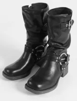 Botas marrones de caña media con hebillas plateadas y taco bajo. Fabricadas en cuero vegano.