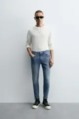 Pantalón de jean color beige, corte skinny, tiro medio, largo cropped y cinco bolsillos.