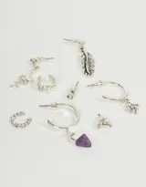 Set de seis aros de plata con diferentes dijes: serpiente, pluma, luna, estrella, cuerno de amatista y strass.