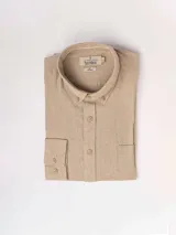 Camisa de manga larga azul, de lino y poliéster, con cuello abotonado y bolsillo en el pecho.