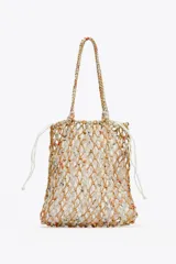 Bolso de mano tipo shopper, tejido con trenzado a contraste de color beige y blanco. Tiene doble asa de hombro y bolsa interior de tela blanca con cierre fruncido.