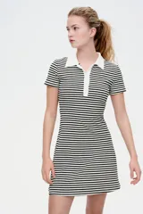 Vestido corto a rayas horizontales blancas y negras, con cuello blanco tipo polo, tapeta de botones y falda acampanada.