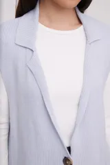 Chaleco gris melange sin mangas, con corte alargado y bolsillos frontales.