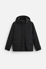 Parka negra de corte regular, confeccionada en tejido técnico acolchado. Tiene cuello alto con capucha ajustable, mangas largas con puños ajustables, bolsillos con solapa en la cadera y un bolsillo interior. El cierre frontal es con cremallera oculta por solapa con botones a presión.