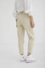 Pantalón de jean color beige, corte recto, con cintura alta fruncida.